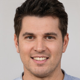 Joyful white young-adult male with short  brown hair and brown eyes