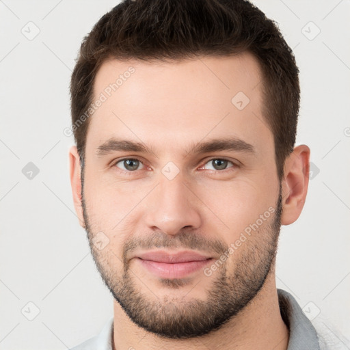 Joyful white young-adult male with short  brown hair and brown eyes