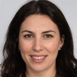 Joyful white adult female with long  brown hair and brown eyes