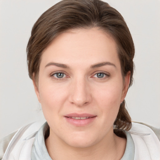 Joyful white young-adult female with medium  brown hair and grey eyes