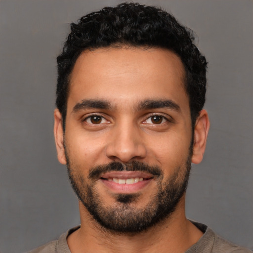 Joyful latino young-adult male with short  black hair and brown eyes