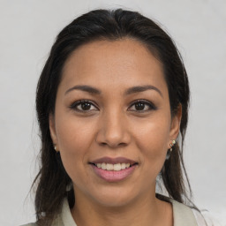 Joyful latino young-adult female with medium  brown hair and brown eyes