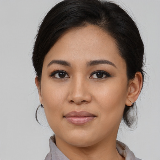 Joyful latino young-adult female with medium  brown hair and brown eyes