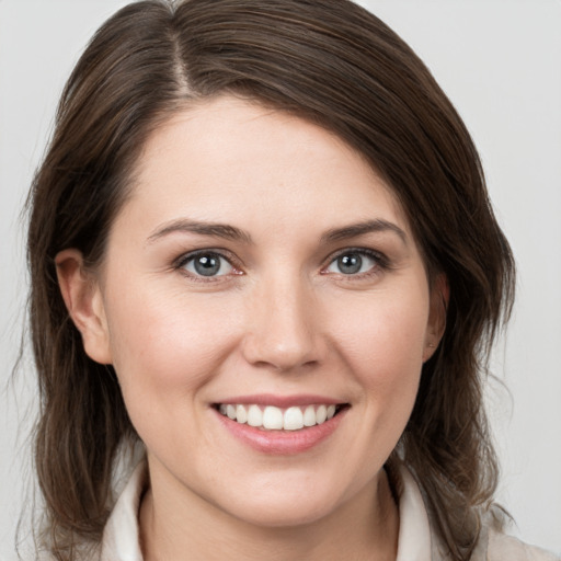 Joyful white young-adult female with medium  brown hair and grey eyes