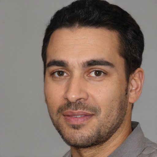 Joyful white young-adult male with short  black hair and brown eyes