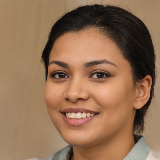 Joyful latino young-adult female with medium  brown hair and brown eyes