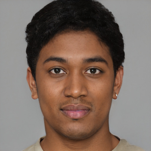 Joyful black young-adult male with short  black hair and brown eyes