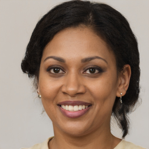 Joyful black young-adult female with long  brown hair and brown eyes