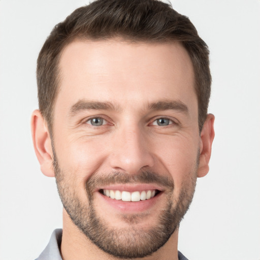 Joyful white young-adult male with short  brown hair and grey eyes