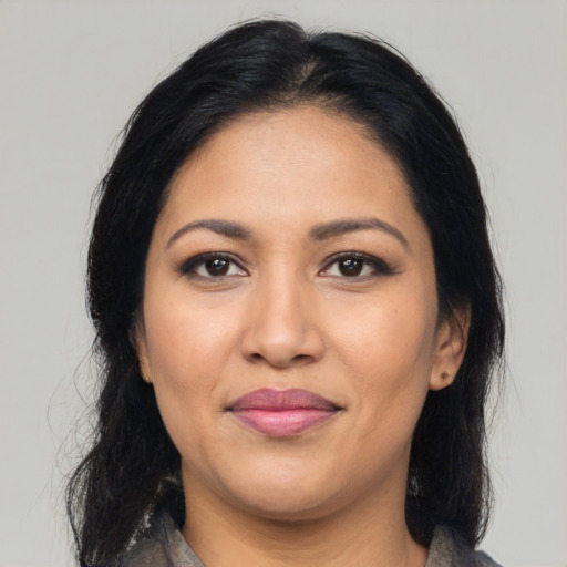 Joyful latino adult female with medium  black hair and brown eyes