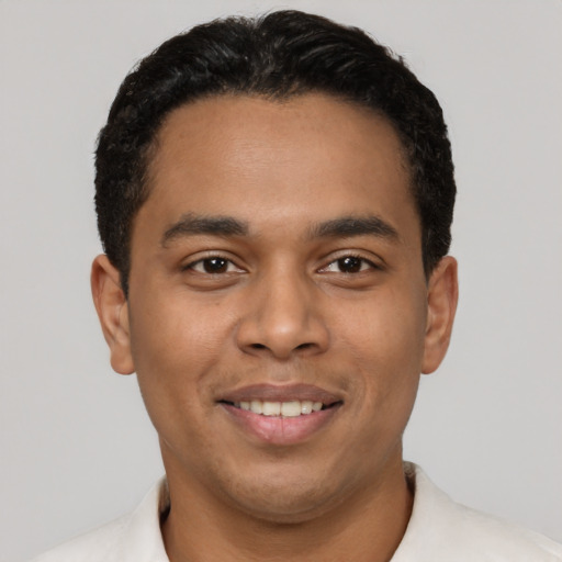Joyful latino young-adult male with short  black hair and brown eyes