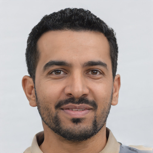 Joyful latino young-adult male with short  black hair and brown eyes