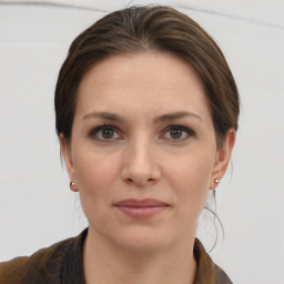 Joyful white young-adult female with medium  brown hair and grey eyes