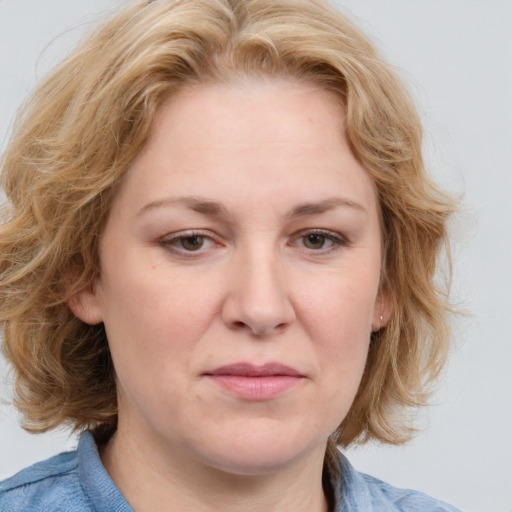 Joyful white adult female with medium  brown hair and blue eyes