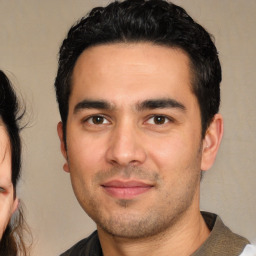 Joyful white young-adult male with short  black hair and brown eyes