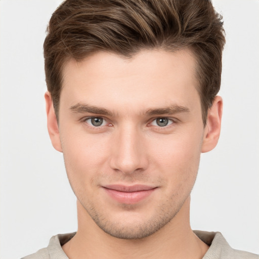 Joyful white young-adult male with short  brown hair and grey eyes