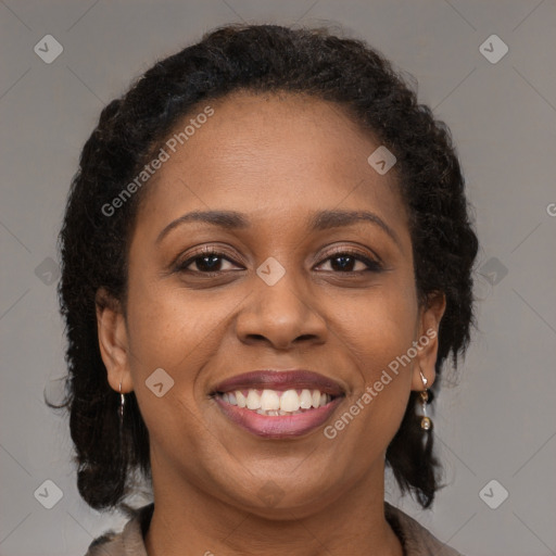 Joyful black young-adult female with long  brown hair and brown eyes