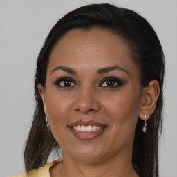 Joyful black young-adult female with long  brown hair and brown eyes