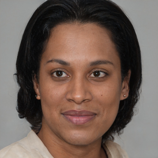 Joyful black adult female with medium  brown hair and brown eyes