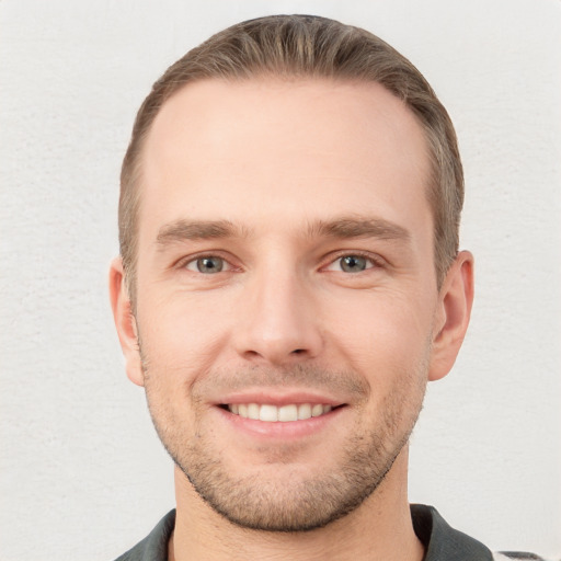 Joyful white young-adult male with short  brown hair and grey eyes