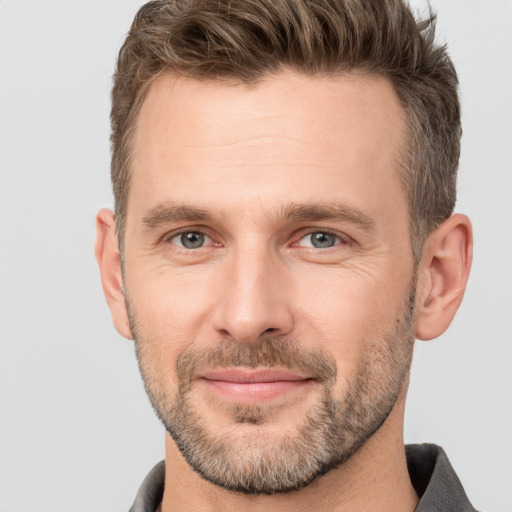 Joyful white young-adult male with short  brown hair and brown eyes