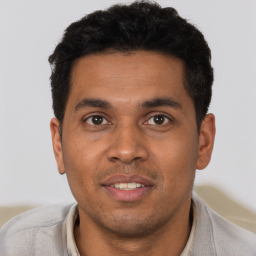 Joyful latino young-adult male with short  black hair and brown eyes