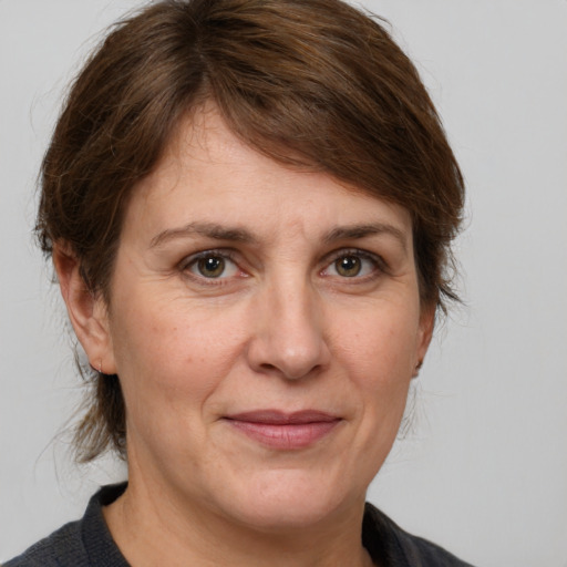 Joyful white adult female with medium  brown hair and grey eyes