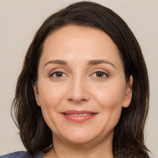 Joyful white adult female with medium  brown hair and brown eyes