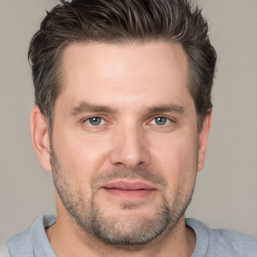 Joyful white adult male with short  brown hair and grey eyes