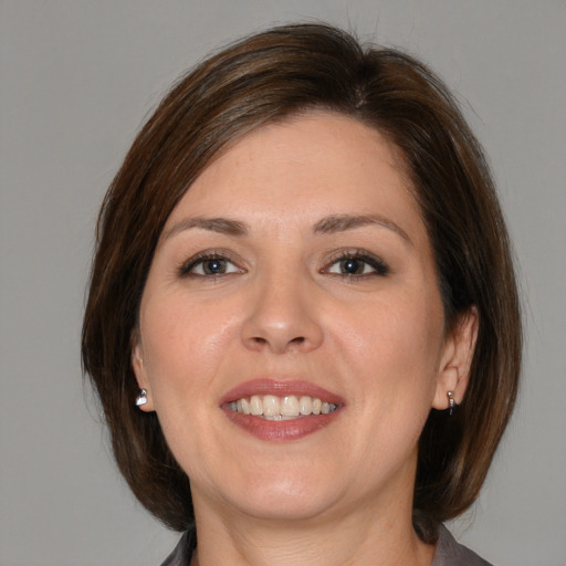 Joyful white adult female with medium  brown hair and brown eyes