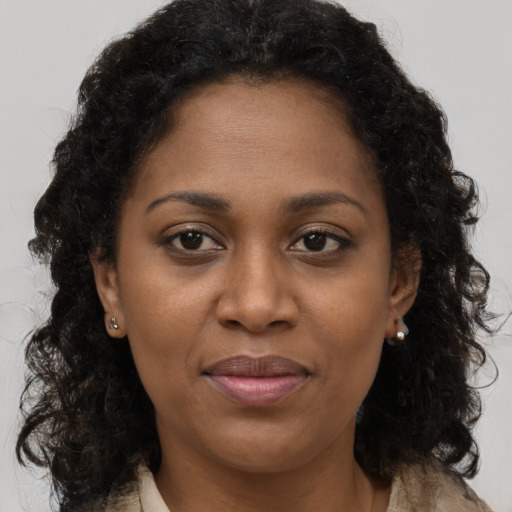 Joyful black young-adult female with long  brown hair and brown eyes