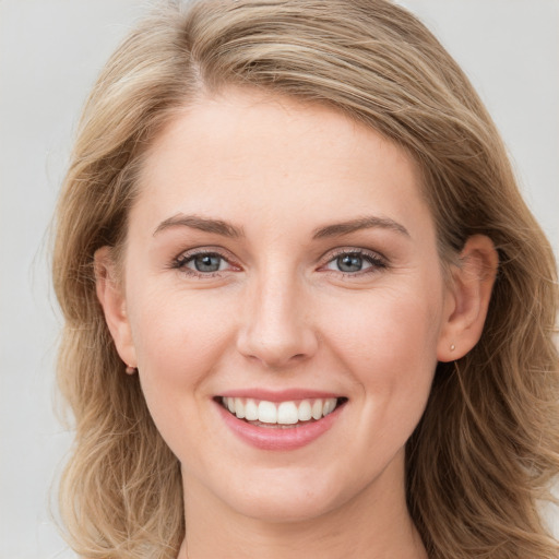 Joyful white young-adult female with long  brown hair and blue eyes