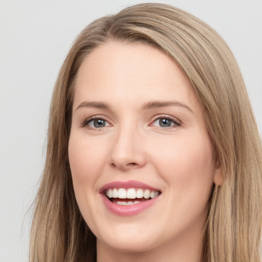 Joyful white young-adult female with long  brown hair and grey eyes