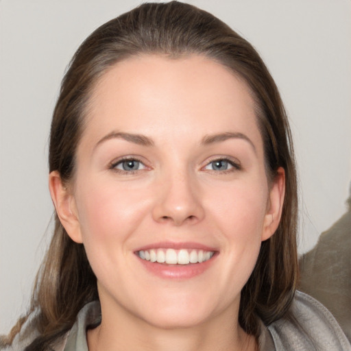 Joyful white young-adult female with medium  brown hair and grey eyes