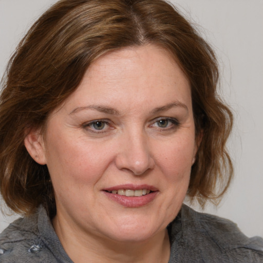 Joyful white adult female with medium  brown hair and blue eyes