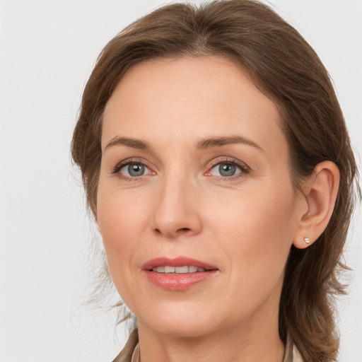 Joyful white adult female with medium  brown hair and grey eyes