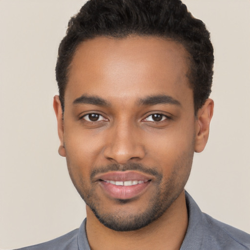 Joyful black young-adult male with short  black hair and brown eyes