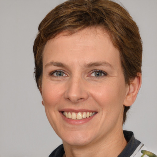 Joyful white adult female with short  brown hair and grey eyes