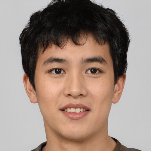 Joyful asian young-adult male with short  brown hair and brown eyes