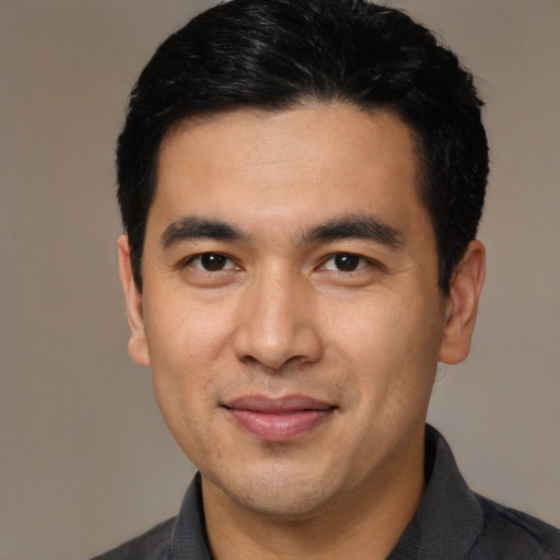 Joyful latino young-adult male with short  black hair and brown eyes
