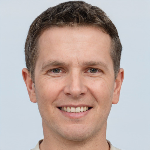 Joyful white adult male with short  brown hair and brown eyes