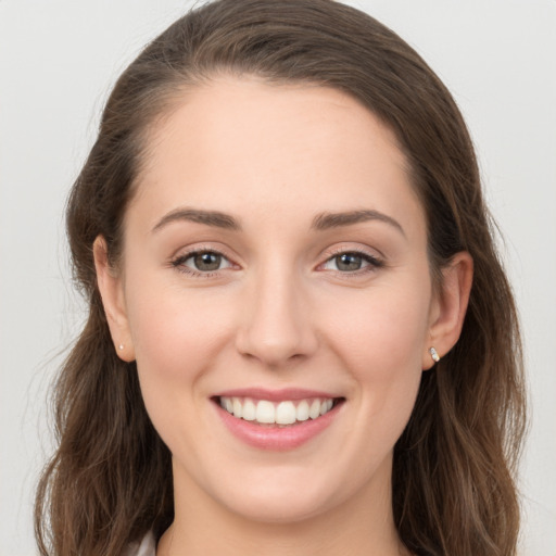 Joyful white young-adult female with long  brown hair and grey eyes