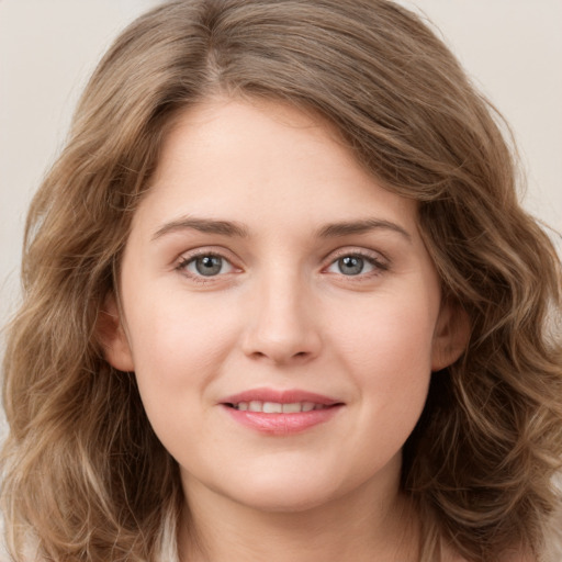 Joyful white young-adult female with long  brown hair and green eyes