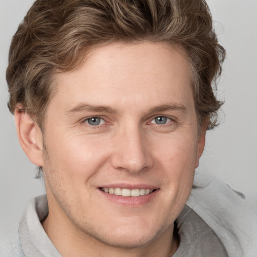 Joyful white adult male with short  brown hair and blue eyes