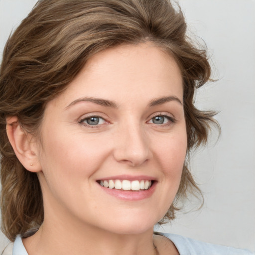 Joyful white young-adult female with medium  brown hair and blue eyes