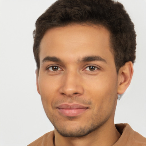 Joyful latino young-adult male with short  brown hair and brown eyes