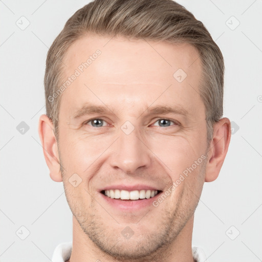 Joyful white young-adult male with short  brown hair and grey eyes