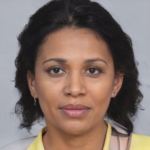 Joyful black adult female with medium  brown hair and brown eyes