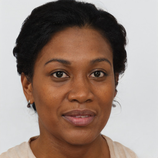 Joyful black young-adult female with short  black hair and brown eyes