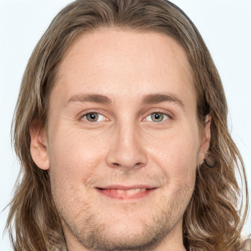 Joyful white adult male with long  brown hair and grey eyes